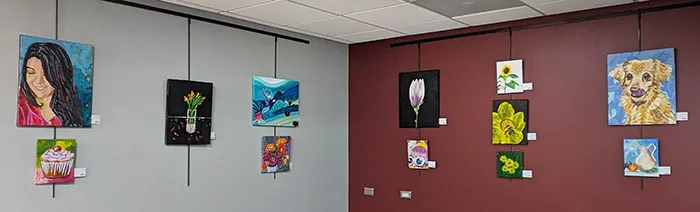 Paintings hanging in the art gallery, which spans 2 walls